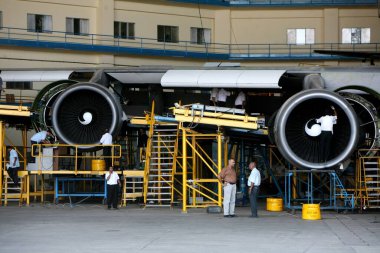 Boeing 747-400 'de çalışan bir grup mühendis, Chhatrapati Shivaji Uluslararası Havalimanı veya Sahar Uluslararası Havalimanı, Bombay Mumbai, Maharashtra, Hindistan merkezli hangarda bakım ve onarım için park etti. 