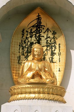 Gold statue of lord Buddha sermon position ; vishwa shanti stupa ; rajgir ; bihar ; india clipart