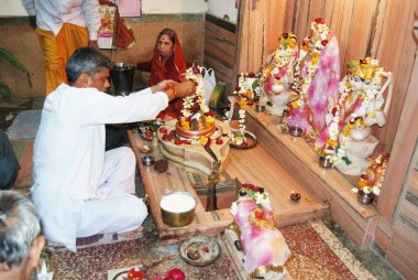 Pundit doing abhishek on Shivlinga, Jodhpur, Rajasthan, India  clipart