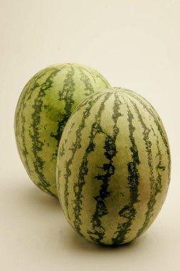 Fruits ; Two full watermelons with light and dark green stripes watery and red from inside ; Pune; Maharashtra ; India clipart