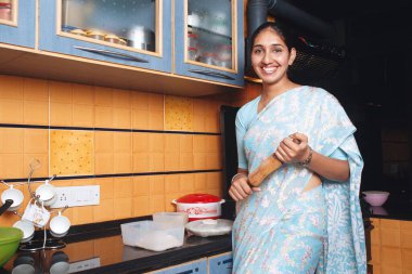 South Asian Indian Woman working in kitchen doing chapatti