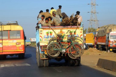 Yolcuları ve bisikletleri taşıyan bir kamyon. 