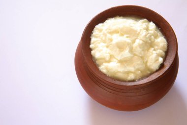 Beyaz arkaplanda toprak tencerede kaymak