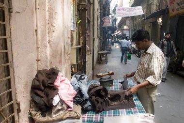 Eski kömür demiriyle giysileri ütüleyen adam; Chandni Chowk; Eski Delhi; Hindistan;