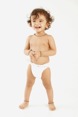 Marwari one year old boy wearing white nappy innocently laughing isolated on white clipart