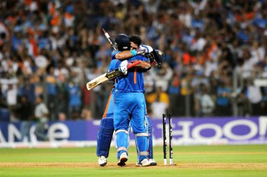 Hint kriket kaptanı Mahendra Singh Dhoni R ve takım arkadaşı Yuvraj Singh, 2 Nisan 2011 'de Mumbai' deki Wankhede Stadyumu 'nda oynanan 2011 Dünya Kriket Kupası finalinde Sri Lanka' yı altı kaleyle yenerek kutladılar.