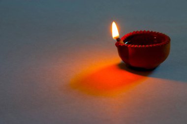 Bir diya kil gaz lambası beyaz arka planda alev gibi bir ışık kaynağı