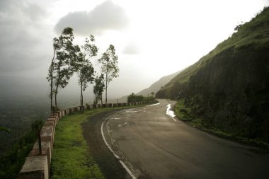 Windy monsoon landscape on winding road of pasarani ghat connecting hill station of Panchgani and Wai ; Maharashtra ; India clipart