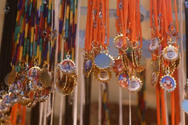 Tipik Harihareshwar Raigad Maharashtra 'nın dışında asılı fotoğraf tanrılarının asılı olduğu renkli kolyeler.