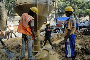 İşçiler, Dr. Ambedkar yolu, Bombay Mumbai, Maharashtra, Hindistan 'da 24 Km uzunluğunda Lalbaug üstgeçidi için beton dolduruyor.