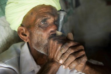 Kırsal kesimde çocuk içen adam, Rajasthan, Hindistan 