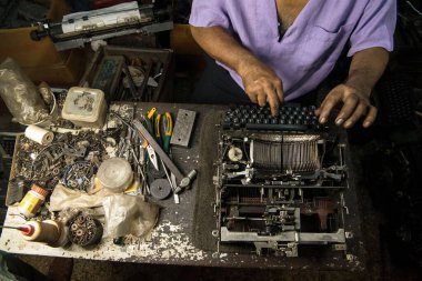 Mumbai, Maharashtra, Hindistan ve Asya 'da eski bir daktiloyu tamir eden teknisyen. 