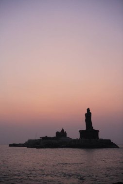 Sunrise view of  Vivekananda Memorial and statue of Tamil Poet Thiruvalluvar located on Rocky Islands ; Kanyakumari ; Tamil Nadu ; India clipart