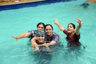 Mother and daughter in swimming pool, raigad, Maharashtra, India, Asia   clipart