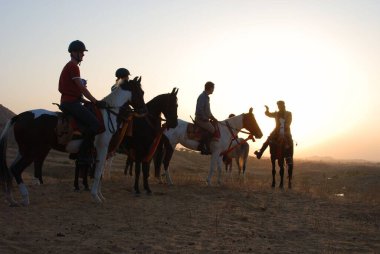 At eğitmeni ve turistler siluette, Pushkar Fair, Rajasthan, Hindistan 