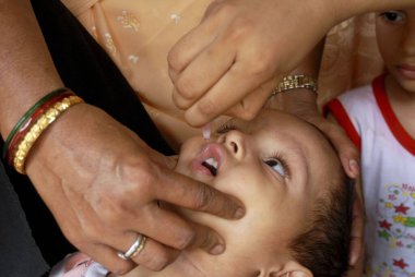 Mumbai, Maharashtra, Hindistan 'daki Pulse Polio Drive sırasında bir çocuğa çocuk felci aşısı uygulayan bir sağlık çalışanı. 