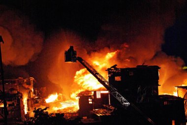 İtfaiyeciler Behrampada gecekondu mahallesinde şnorkel kullanarak yangın söndürüyorlar; Bandra; Bombay Mumbai; Maharashtra; Hindistan 18-Haziran-2009
