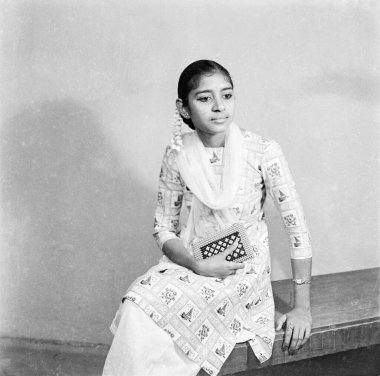 Eski model 1900 'lerin siyah beyaz stüdyo resmi. Hint kızı, Salwar Kameez marka çanta takıyor. El saçı Hindistan çiçeği.