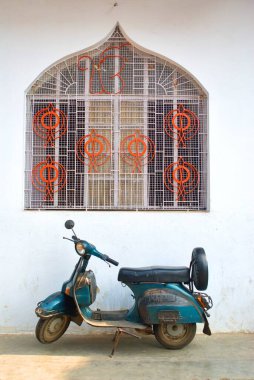 Scooter parked under window at Asansol, West Bengal, India  clipart