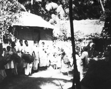 Mahatma Gandhi 'nin kulübesinin önünde Noakhali yürüyüşünde ona eşlik etmek için bekleyen insanlar Kajir Khil' e yürüyor.  