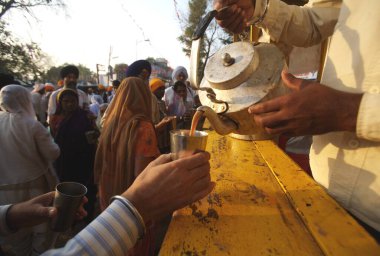 Nanded, Maharashtra, Hindistan 'daki Sachkhand Saheb Gurudwara yerleşkesindeki müritlere çay servisi yapılıyor. 