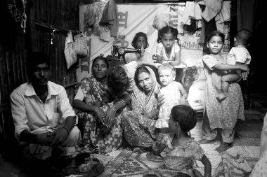 Malvani gecekondu mahallesi, Malad, Bombay Mumbai, Maharashtra, Hindistan 'da dikiş makinesi olan bir aile.   