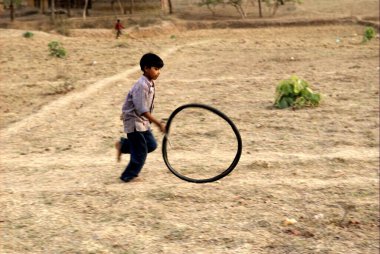 Lastiklerle oynayan köylü çocuk, Rajouli, Nawada, Bihar, Hindistan 