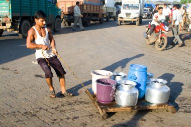Bombay Mumbai, Maharashtra, Hindistan 'da su arabası çeken gecekondu çocuğu.   