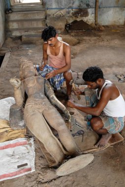 Heykeltraşlar keskiyle bronz simge oydular. 