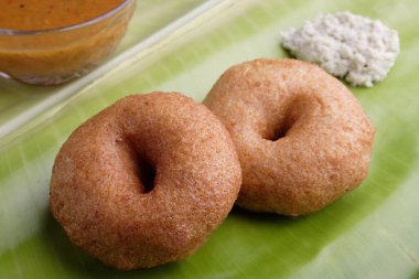 Hint usulü kızarmış medu wada muz yaprağında acı sos ve sambhar.