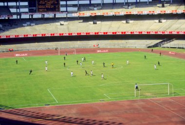 Hintli erkekler gündüz stadyumda futbol oynuyorlar. 