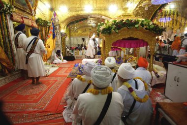 Sih rahipler oturuyor, Guru Granth Sahib Sikh, Sachkhand Saheb Gurudwara 'nın 300. yıl kutlamaları Nanded, Maharashtra, Hindistan' da 