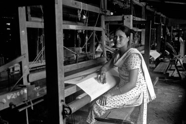Bodo woman weaving on handloom, Assam, India    clipart