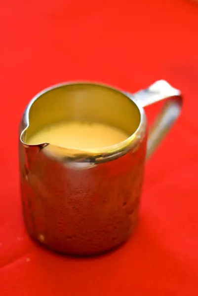 stock image Kettle of cold milk on red table, Goa, India