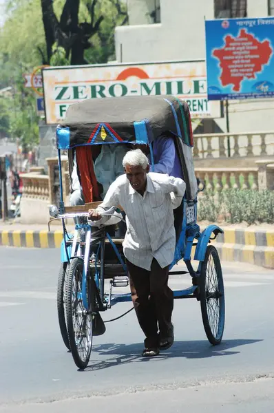 stock image A old cycle rickshaw puller carrying passengers at Nagpur, Maharashtra, India 