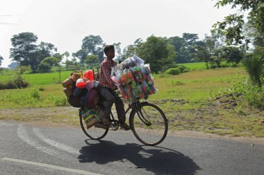 Sambalpur Orissa Hindistan 'da bisiklet üstünde oyuncak taşıyan bir adam.