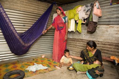 Bir inşaat alanında çalışan anne çocukları, Ahmedabad 'ı, Gujarat' ı, Hindistan 'ı beslemek ve yatıştırmak için kısa bir mola veriyor.  
