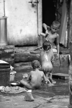 Byculla gecekondu mahallesinde banyo yapan çocuklar, N M Joshi Yolu, Bombay Mumbai, Maharashtra, Hindistan   