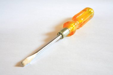 Beyaz zemin üzerine sarı saplı tornavida