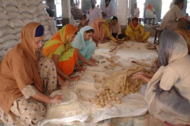 Langar, community kitchen, free food-guru ka langar, the gurus kitchen introduced by guru Amar Das to melt the caste barriers and to provide free food for thousands of pilgrims through voluntary service, Golden temple, Amritsar, Punjab, India  clipart