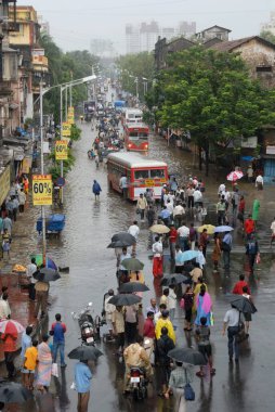Muson yağmurları, sel basmış yollarda yürüyen insanlar Parel, Bombay Mumbai, Maharashtra, Hindistan 