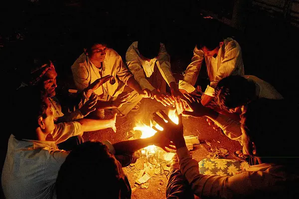 stock image Hutment or slum dwellers sit around bonfire warming in winter season