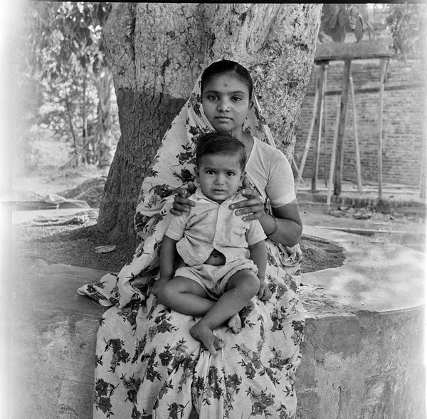 stock image old vintage 1900s black and white picture of Indian mother son portrait under tree India 1940s 