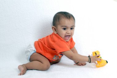 Hintli bebek sevinçle sürünüyor plastik ip temizleyici toplamak için. 