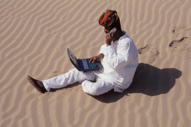Cep telefonu ve laptop kullanan adam, Jaisalmer Çölü Rajasthan, Hindistan