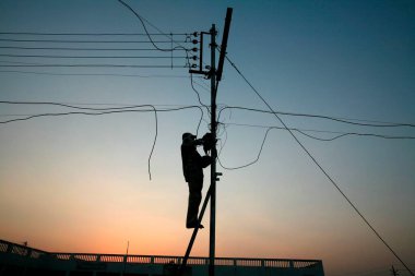 Bhopal, Madhya Pradesh ve Hindistan 'da elektrik direkleri üzerinde çalışan elektrik departmanı personeli.