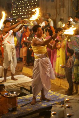 Genç rahip Ganga nehrinin kıyısındaki ghat 'ta ganga pooja yapıyor, Varanasi, Uttar Pradesh, Hindistan 