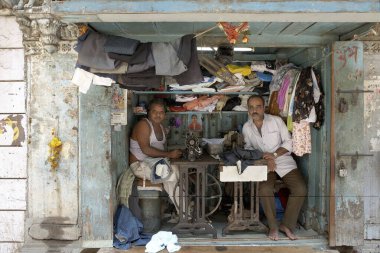 İki dikiş makinesi ve tabure koyacak kadar büyük bir alan Mumbai Bombay, Maharashtra, Hindistan 'da işlek bir terzi dükkanı haline geliyor. 