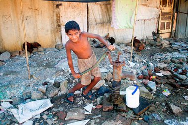 El pompasından su pompalayan çocuk, Malvani gecekondu mahallesi, Malad, Bombay Mumbai, Maharashtra, Hindistan  