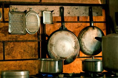 Mutfak duvarında asılı öğütücüler ve tavalar